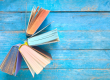 cuatro libros encima de una mesa de color azul